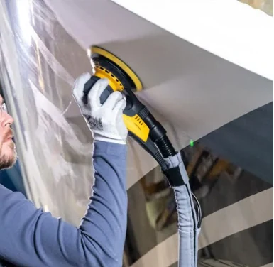 Boat surface being sanded with a dust-extraction sander