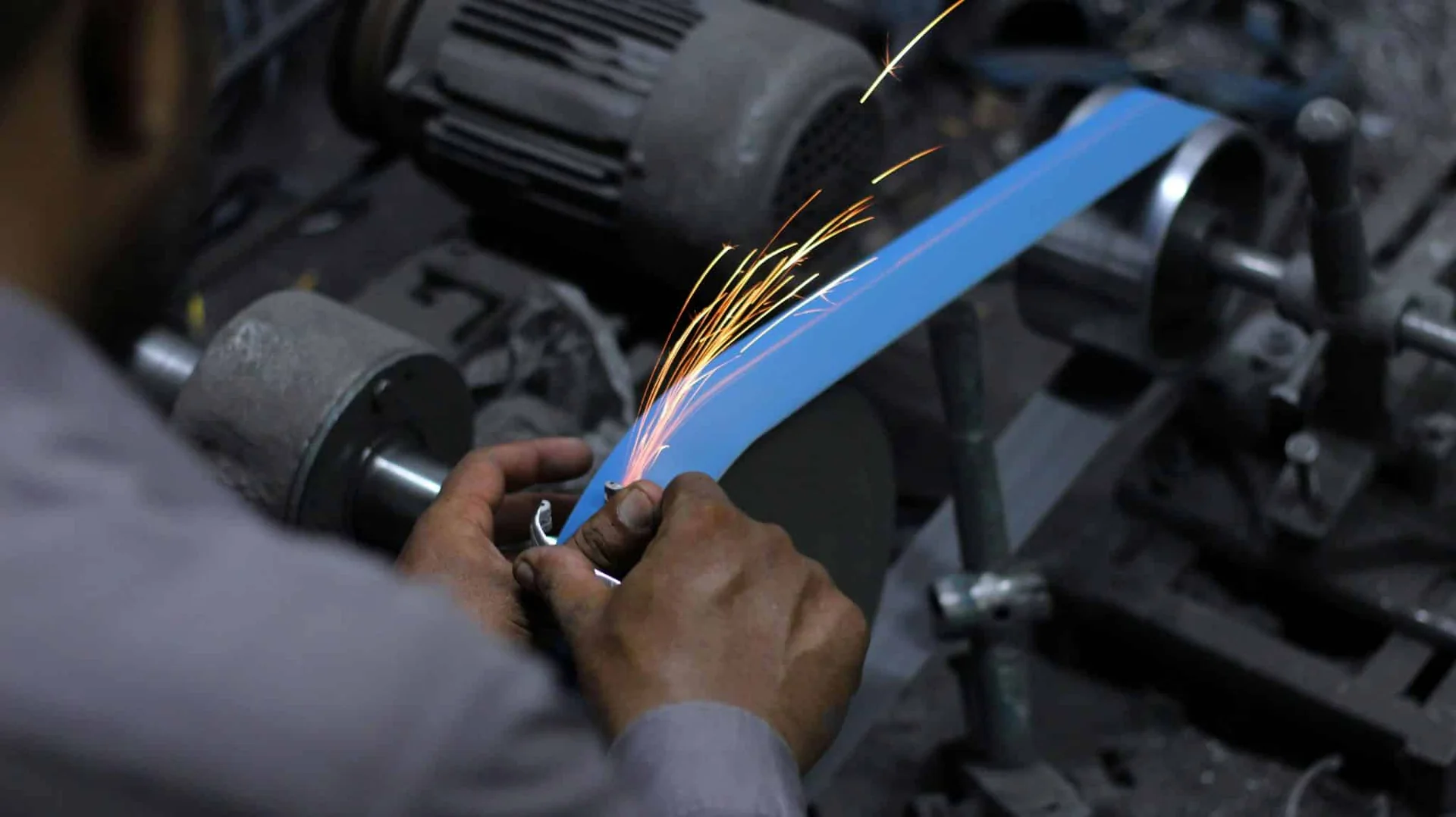 Abrasive belt sanding a metal component