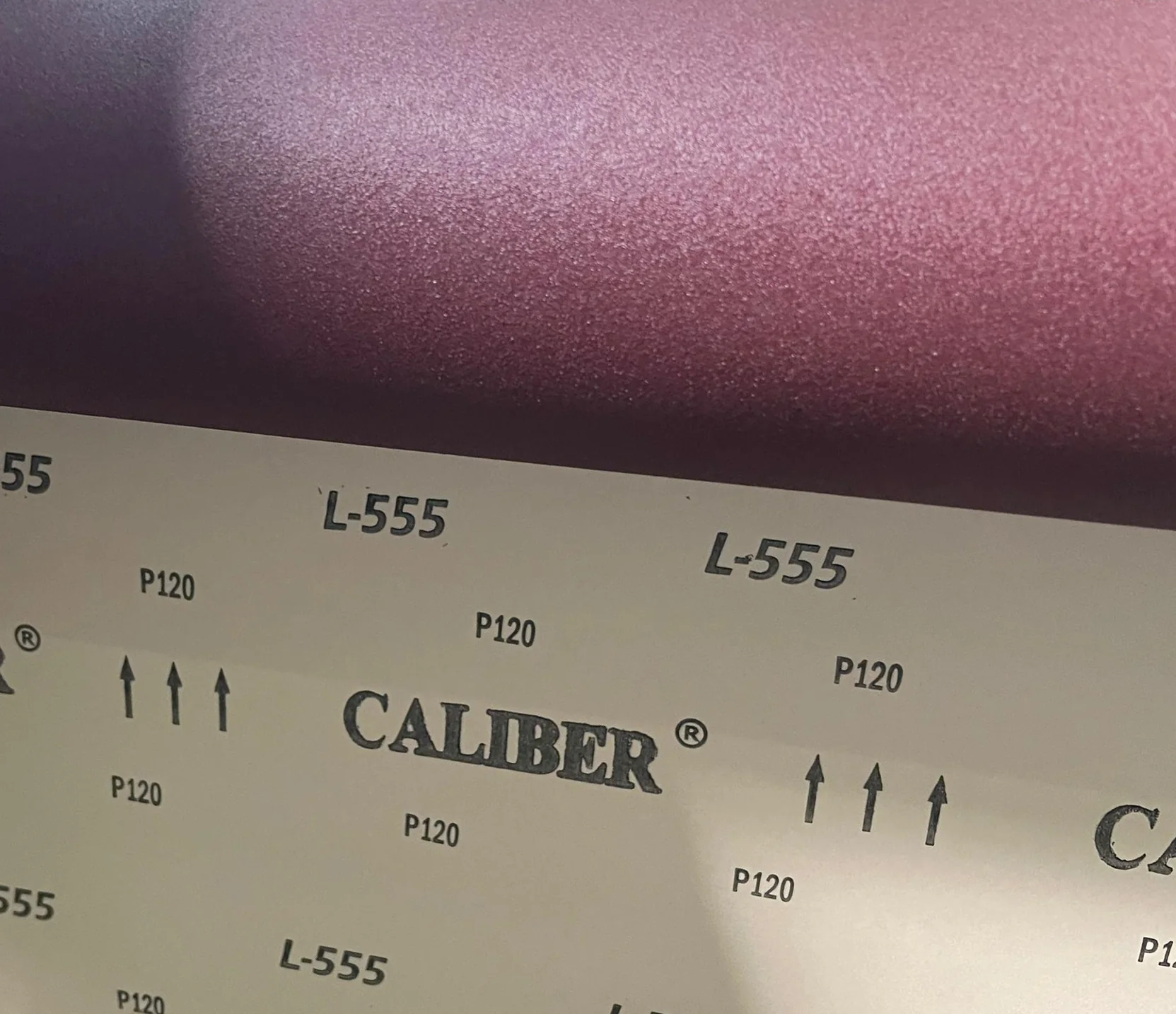 CALIBER L-555 abrasive sample showing the abrasive face and cloth backing