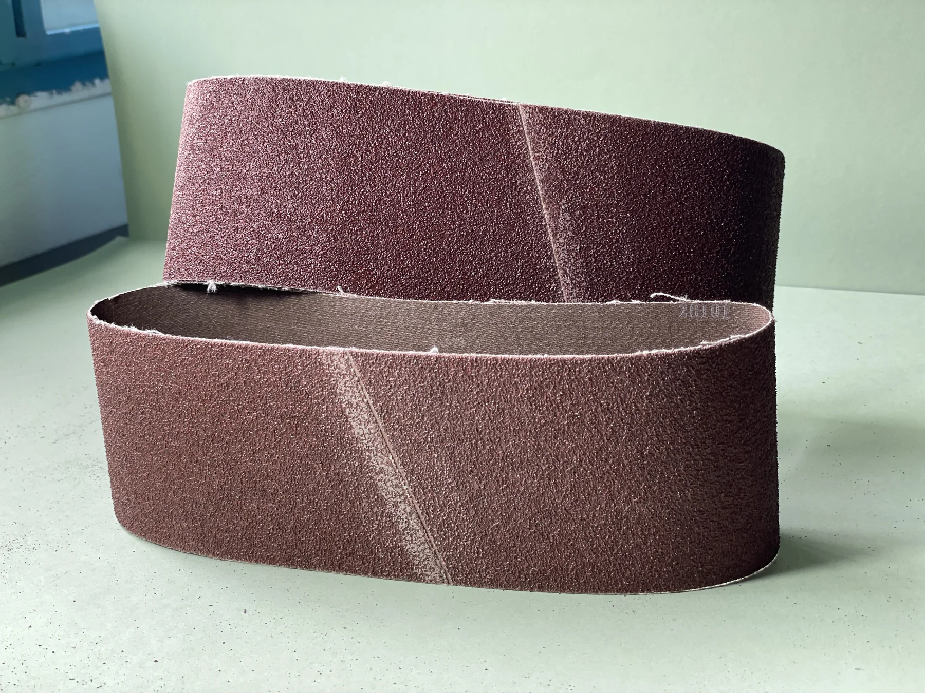 Finished sanding belts standing upright with their belt joints visible